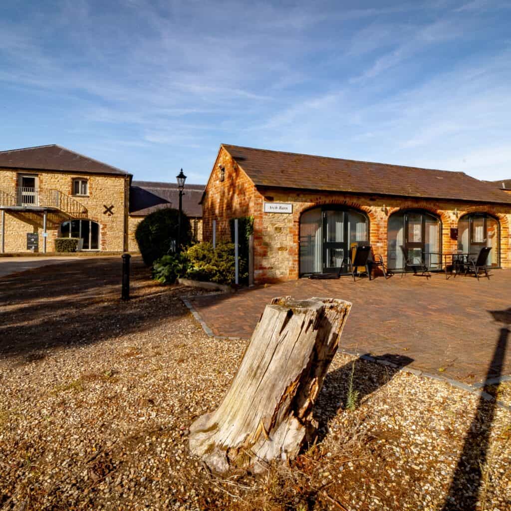 Exterior view of Blisworth Hill Offices with brick building and outdoor seating.