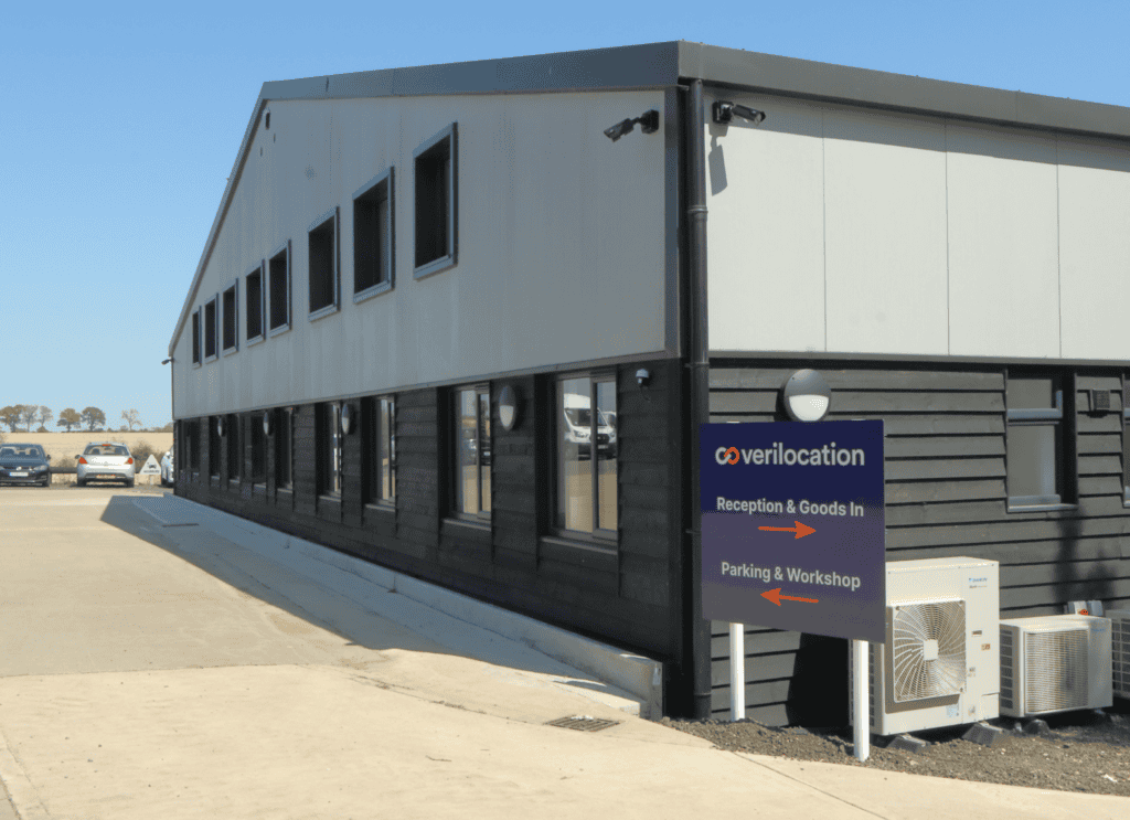 Modern two-story commercial building with Verilocation signage and parking area.